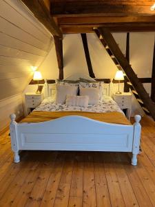a bedroom with a white bed in a attic at Gîte aux charmes d'Antan in Weinbourg