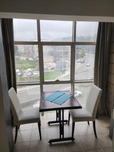 a table and two chairs in front of a window at HighLand suites in Aley