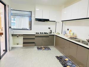 a kitchen with white cabinets and a sink at Diamond Oark Residency in Gatunga