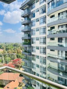 a tall white apartment building with a balcony at Diamond Oark Residency in Gatunga