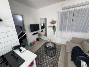 a living room with a couch and a tv at הבית של גיא בנאי in Beer Sheva