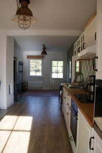 a kitchen with white cabinets and a wooden floor at Ferienhaus Lilli in Pruchten