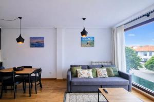 a living room with a couch and a table at Llanes Celorio Piscina y Playa – El Castro Borizu in Celorio