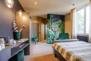 a hotel room with a bed and a large window at Les Loges Du Parc in Gérardmer