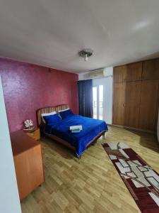 a bedroom with a blue bed and a red wall at HighLand suites in Aley
