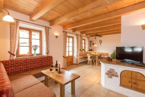 a living room with a couch and a tv at Schauerhof in Chieming