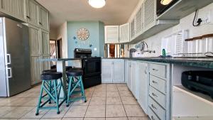 a kitchen with a counter and stools in it at Uvongo Cabanas 13B in Uvongo Beach