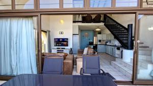 a living room with a table and chairs and a kitchen at Uvongo Cabanas 13B in Uvongo Beach
