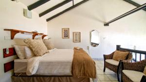 a bedroom with a bed and a chair at Uvongo Cabanas 13B in Uvongo Beach +12 photos