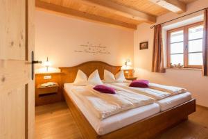 a bedroom with a large bed with purple pillows at Schauerhof in Chieming