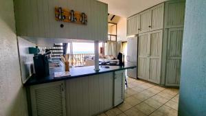 a kitchen with white cabinets and a counter top at Uvongo Cabanas 13B in Uvongo Beach