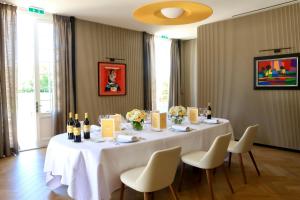 a white table with chairs and bottles of wine at La Chartreuse de Dauzac in Labarde