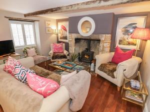 a living room with two couches and a fireplace at Bumblebee Cottage in Tetbury