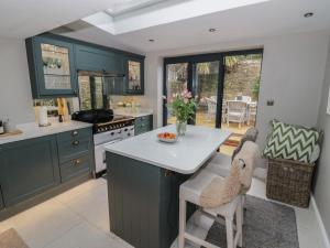 a kitchen with blue cabinets and a white counter top at Bumblebee Cottage in Tetbury