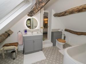 a bathroom with a sink toilet and a mirror at Bumblebee Cottage in Tetbury +30 photos