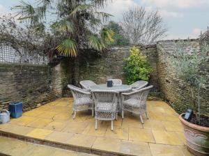 a table and chairs sitting on a patio at Bumblebee Cottage in Tetbury