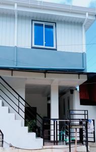 a house with a balcony with a blue roof at MJ's Guesthouse in Tubod +7 photos