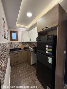 a kitchen with a black refrigerator and a sink at Casa Sole Sharm Hills Apt 4 in Sharm El Sheikh