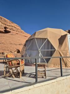 a tent and two chairs in the desert at Sofia Bubble Luxury Camp in Disah