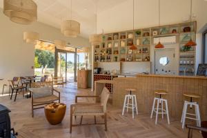 a restaurant with a bar with chairs and tables at Les Coteaux - Lodges & Expériences in Laparade