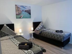 ein Schlafzimmer mit zwei Betten und einem Gemälde an der Wand in der Unterkunft Checkinn Hotel in Bad Salzuflen