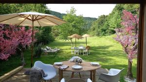 a table with chairs and an umbrella in a garden at CHALET de la CHEVANNE in Laissey