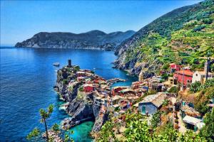 a village on the side of a mountain next to the water at Hotel Mary in La Spezia