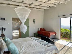 a bedroom with a bed and a window at Jabula Beach House in Mngazana +21 photos