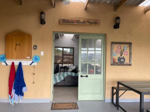 a front door of a house with a sign that reads double beach house at Jabula Beach House in Mngazana