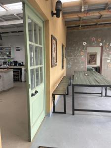 a room with a table and a bench and a door at Jabula Beach House in Mngazana