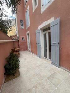 an empty courtyard of a building with blue doors at Cocon de Nuit - appartement RDC, avec terrasse in Orange