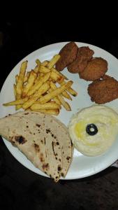 a plate of food with french fries and chicken nuggets at YAARI Shangarh in Shangarh