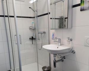 a white bathroom with a sink and a shower at Apartment Keller in Savognin +20 photos
