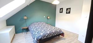 a bedroom with a bed and a green wall at Gite Les 4 Moustaches in Bourbourg