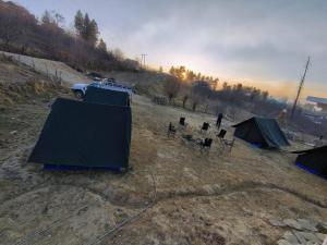 a group of tents and a truck in a field at Chanshal Camp in Khashdhār