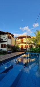 a house with a swimming pool in front of a house at Vila Cacau pousada - Serra Grande in Serra Grande