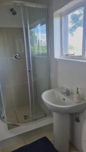 a white bathroom with a shower and a sink at HiddenValley in Chartwell +27 photos