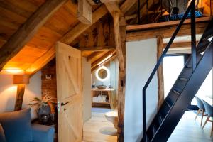 an attic room with wooden ceilings and a staircase at Vakantiewoning Lemselermaten in Weerselo
