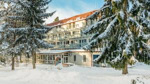 a hotel in the winter with snow covered trees at Resort Niegocin in Wilkasy