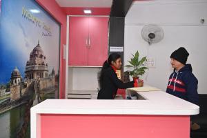 two people standing at a counter in a room at Maurya Royal in Sasarām