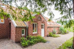 a red brick house with a white door at Doppelzimmer Holthusen 25515 in Weener