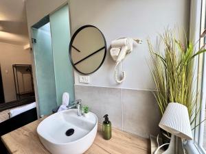 a bathroom with a sink and a mirror at E - Central Room Two in Skopje