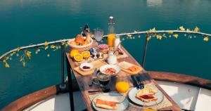 a table with food and orange juice on a boat at Boat Haus - Casas Flotantes frente a Gibraltar in La Línea de la Concepción