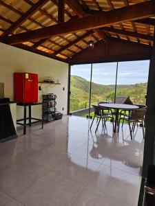 a room with a table and chairs and a large window at Recanto do Guará Cabana in Capitólio