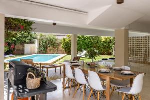 a dining room with a table and chairs and a swimming pool at Villa Palma in Palma de Mallorca