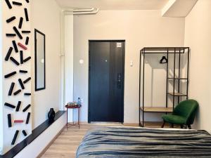 a bedroom with a blue door and a green chair at E - Central Room Two in Skopje +7 photos
