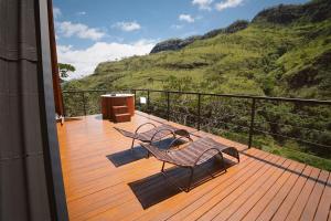 a balcony with a bench and a view of a mountain at Recanto do Guará Cabana in Capitólio
