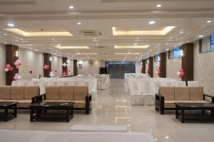 a banquet hall with white chairs and tables and pink balloons at Shagun Hotel & Banquet in Lucknow
