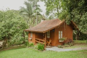 a small wooden house in the middle of a yard at Pousada Fazenda Caetés in Camboriú