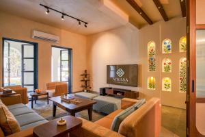 a living room with orange furniture and a tv at Niwasa - A Luxury Boutique Stay, Udaipur in Udaipur